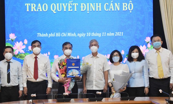 Phó Chủ tịch UBND TPHCM Võ Văn Hoan trao quyết định và tặng hoa cho ông Lê Văn Cửa
